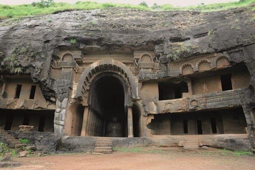 Una entrada a templo excavada en la roca, con un gran arco y múltiples aberturas más pequeñas. 5