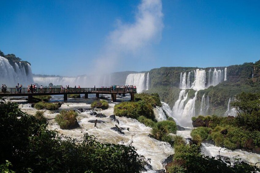 A large waterfall with multiple cascades, a viewing platform, and lush greenery. 1