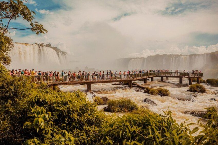 Une cascade, un pont en bois et une foule de personnes. 4