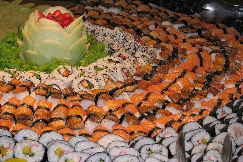 A variety of sushi arranged in a circular pattern with a decorative centerpiece. 1