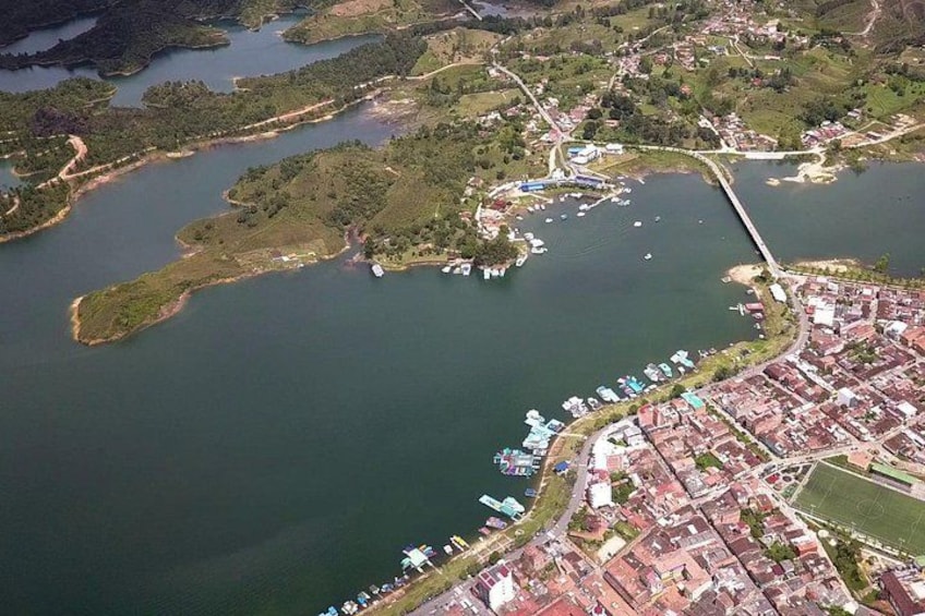 An aerial view of a coastal town with a marina, residential areas, and surrounding water bodies. 1