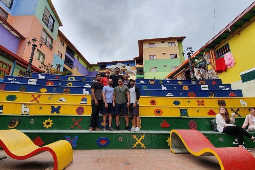 Colorful steps with various symbols, a group of people standing on them, and a building in the background. 3