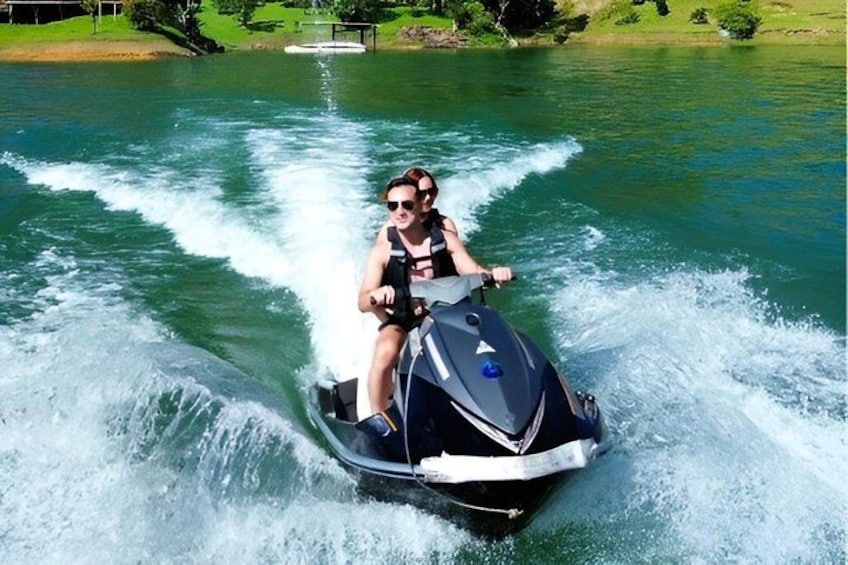 Eine Person fährt mit einem Jetski über das Wasser, wobei sich eine Welle hinter dem Jetski bildet. 4