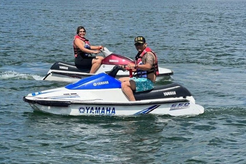 Zwei Personen fahren auf einem Yamaha Jet-Ski über das Wasser. 2