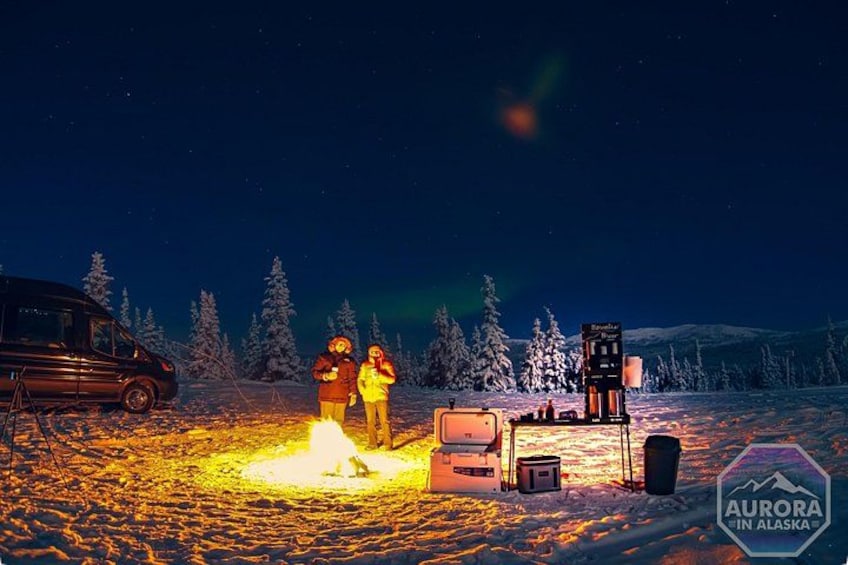 Un paysage enneigé avec un feu de camp, des tentes et un véhicule. 4