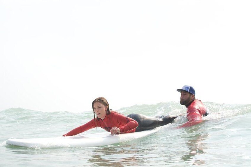 Two people on a surfboard in the ocean. 1