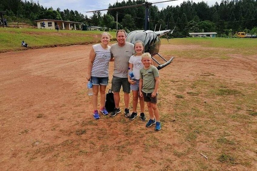 A group of people standing on a dirt path with a large aircraft in the background. 2