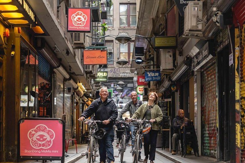 A narrow street with bicycles, storefronts, and signs. 3
