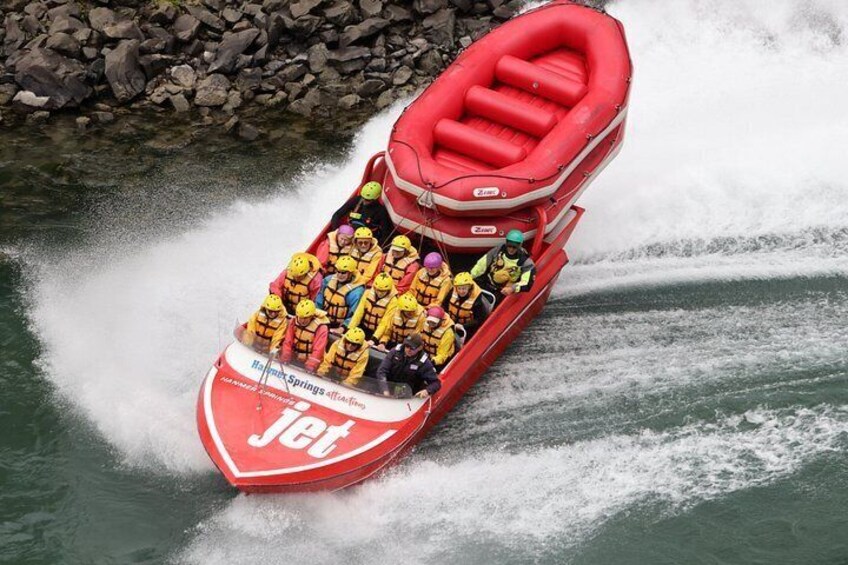 A red Jet watercraft with passengers wearing life jackets. 2