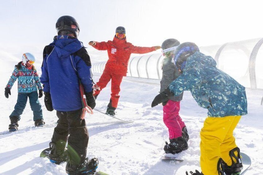 A group of people snowboarding on a snowy slope. 5