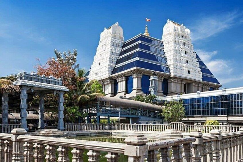 Un temple doté d’une grande tour centrale, d’une tour plus petite et d’un bâtiment moderne en verre, situé au premier plan. 4