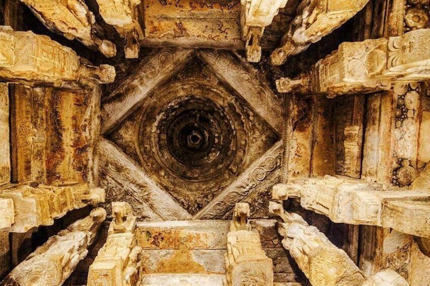 An ancient stone structure with intricate carvings and a central circular design. 1