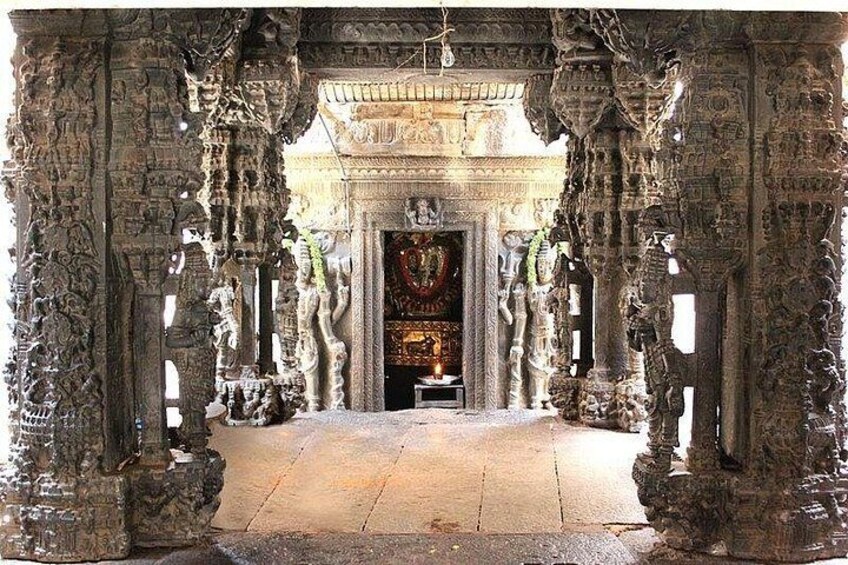 An ancient temple entrance with intricate carvings and a central shrine. 5