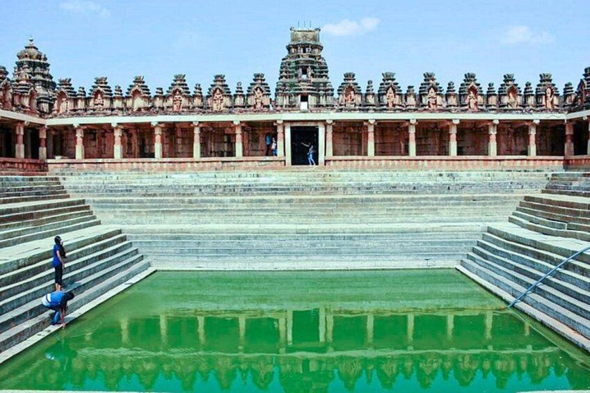 A temple with tiered architecture, a central courtyard, and a reflection pool. 2