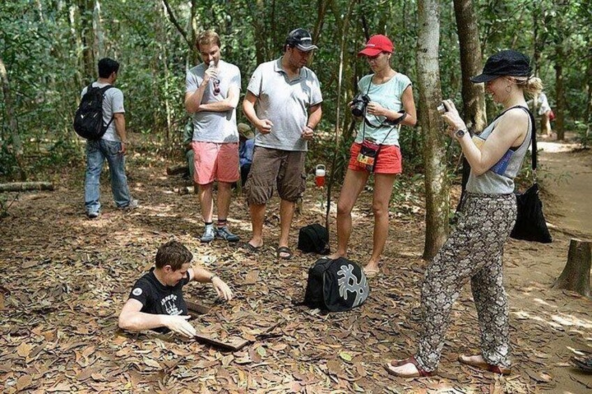Un grupo de personas en una zona boscosa, algunas de pie y otras sentadas en el suelo. 2