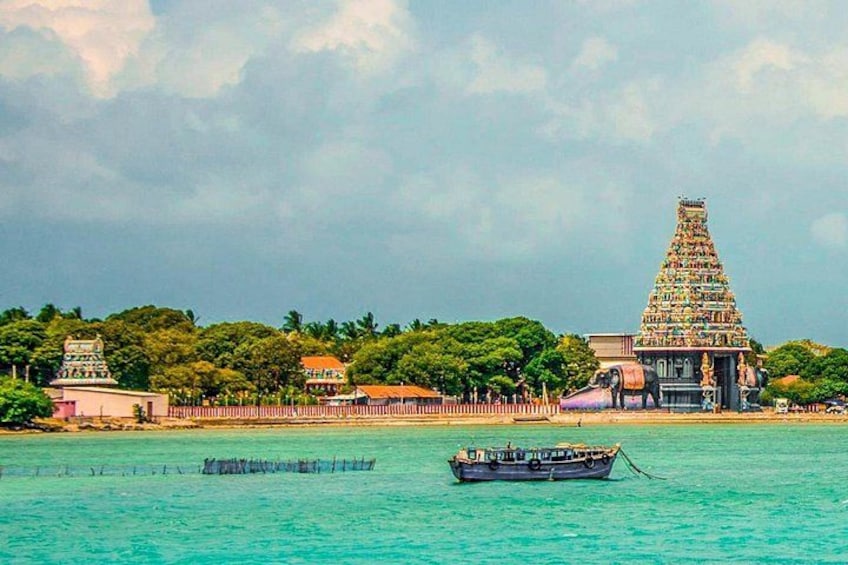 A temple with a tiered tower, a body of water, and a boat. 1