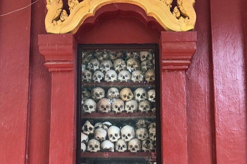 A red building with a window displaying multiple skulls. 5