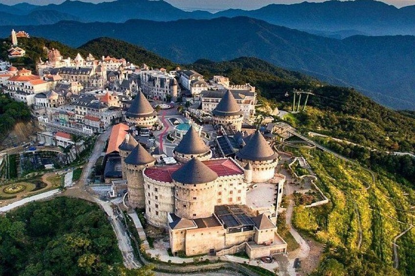 A mountainous town with historic buildings and a castle-like structure. 4