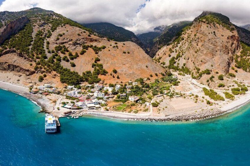 A coastal town with a beach, boats, and mountainous terrain. 2
