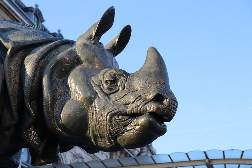 Une statue en bronze représentant un rhinocéros, avec une texture détaillée et une corne recourbée. 5