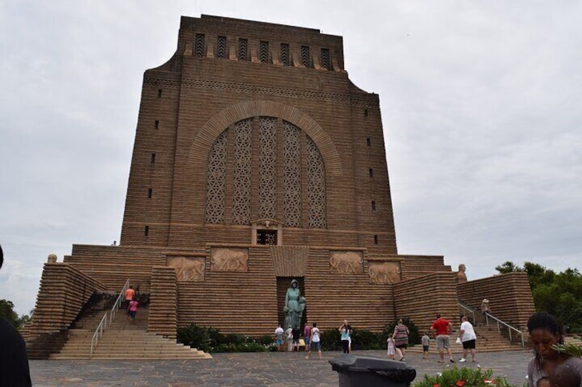 A large, ornate building with a central arched window and steps leading up to it. 2