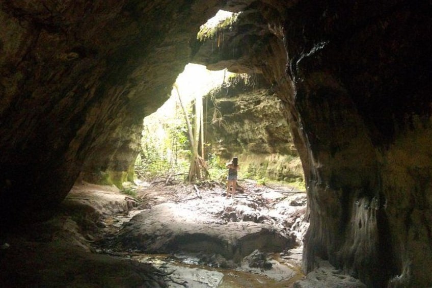A cave entrance with a person standing inside. 2