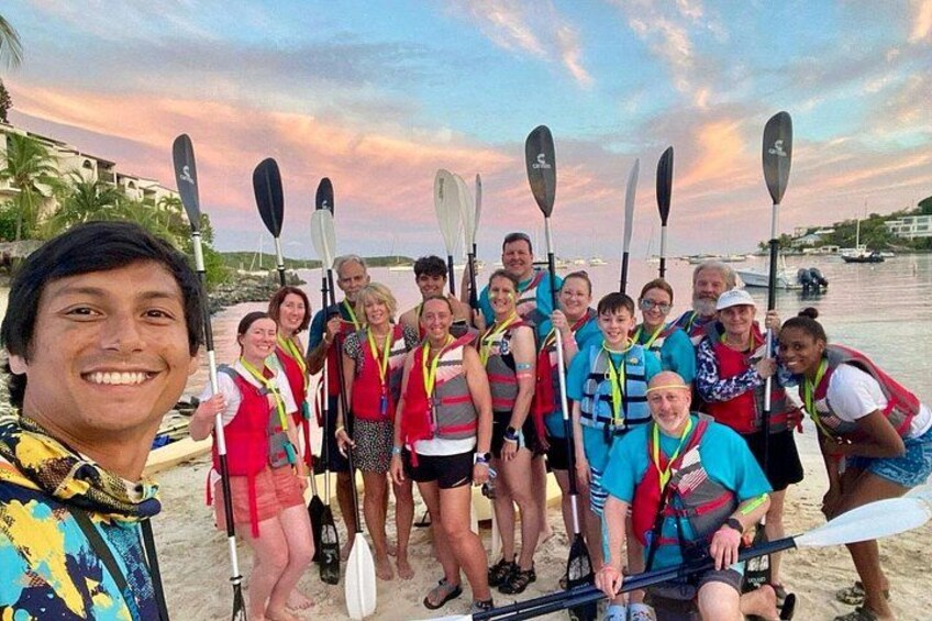 Un groupe de personnes sur une plage, avec des kayaks et des pagaies. 2