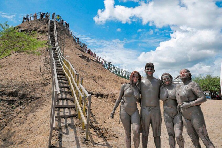 A sandy hill with a wooden staircase, people climbing, and a clear sky. 3