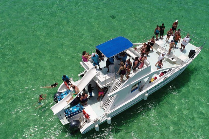 A boat with people on it in clear water. 1
