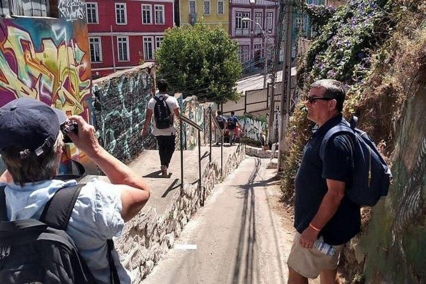 Una persona fotografiando, una escalera y un muro lleno de grafitis. 5