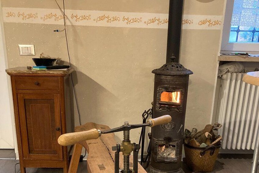 A wood-burning stove, a wooden cabinet, and a window with curtains. 3
