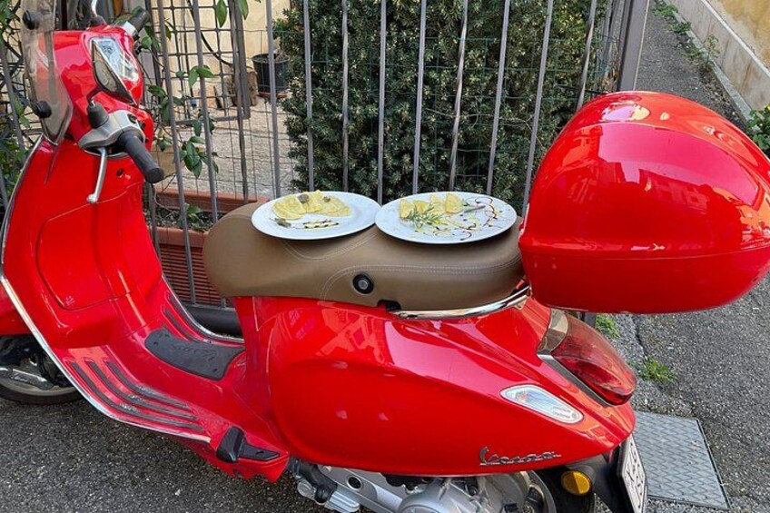 A red scooter with a brown seat and two plates on it. 5