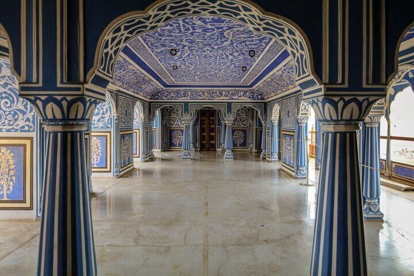 Una sala sfarzosa con decorazioni blu e oro, colonne e un soffitto a motivi. 2