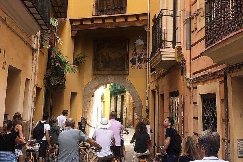 Une rue animée, pleine de monde, où l’on voit des gens qui se promènent, et un grand arc de triomphe. 1