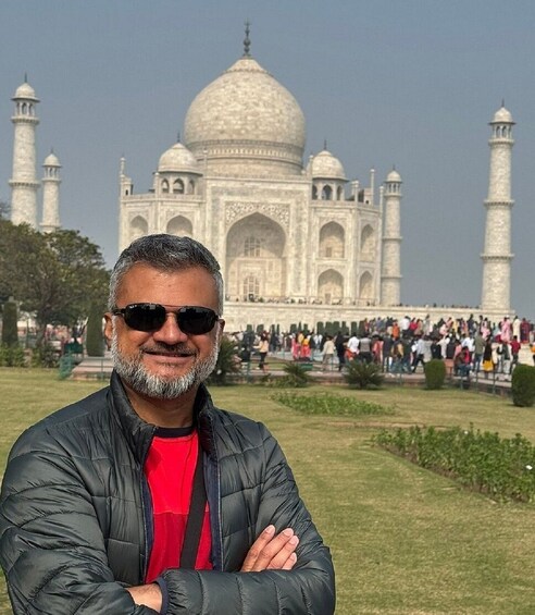 A person standing in front of the Taj Mahal with the monument in the background. 3