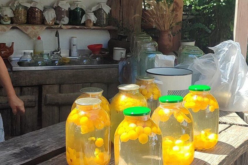 Glass jars with yellow contents and green lids on a wooden surface. 4