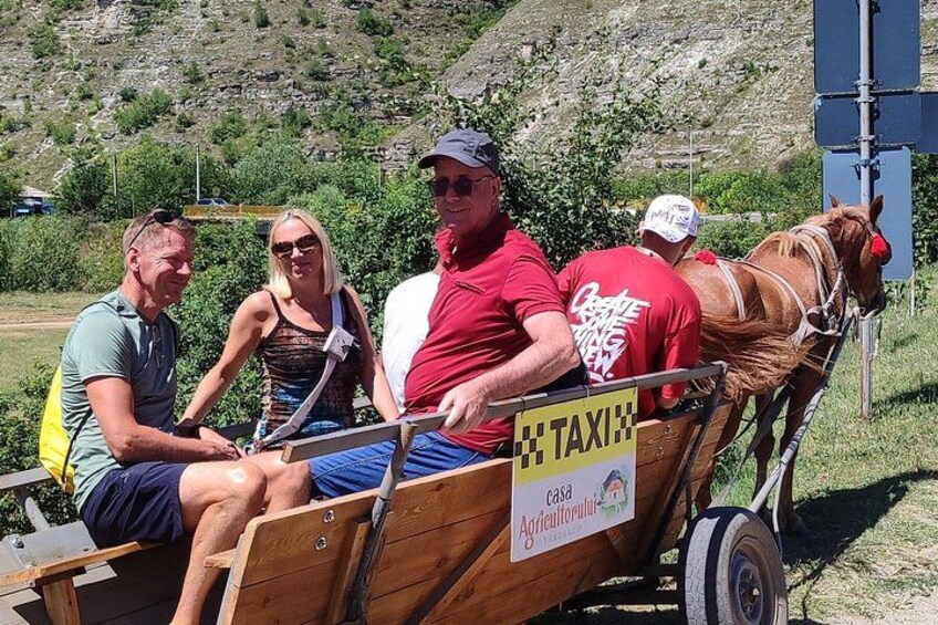A wooden cart with a horse, people sitting, and a sign that says 'TAXI'. 3