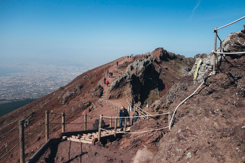 A rocky mountain path with wooden steps and a rope railing. 4