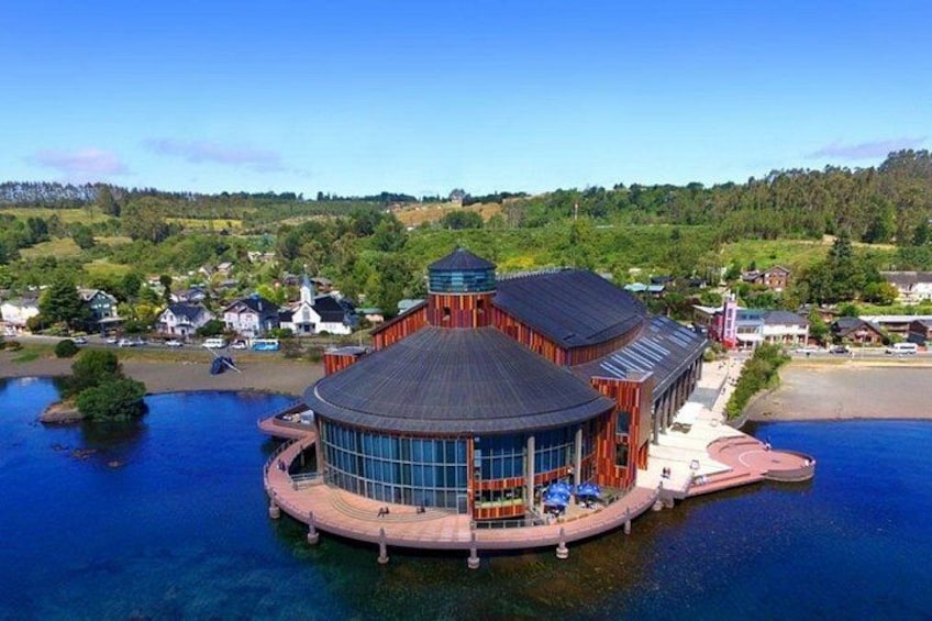 Un bâtiment situé au bord de l’eau, de forme circulaire, entouré d’eau et de verdure. 5