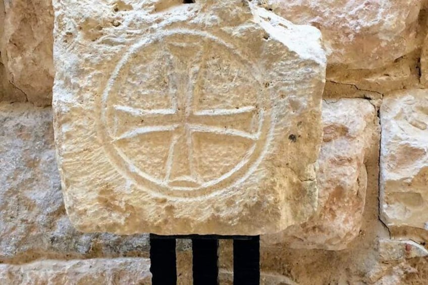 A stone with a carved cross and circle. 4