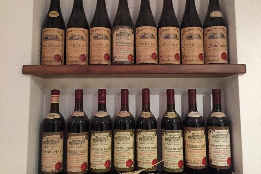 A collection of wine bottles on shelves. 2