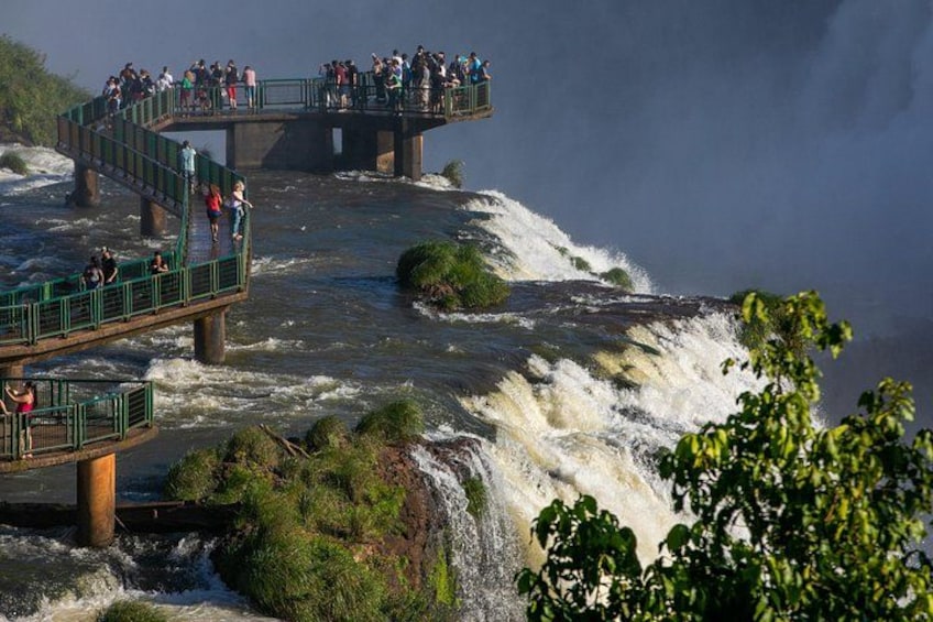 A bridge over a river with people walking and standing on it. 3