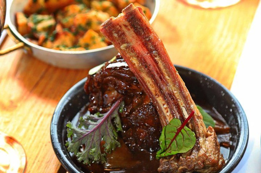 A bowl of food with a piece of meat and greens. 3
