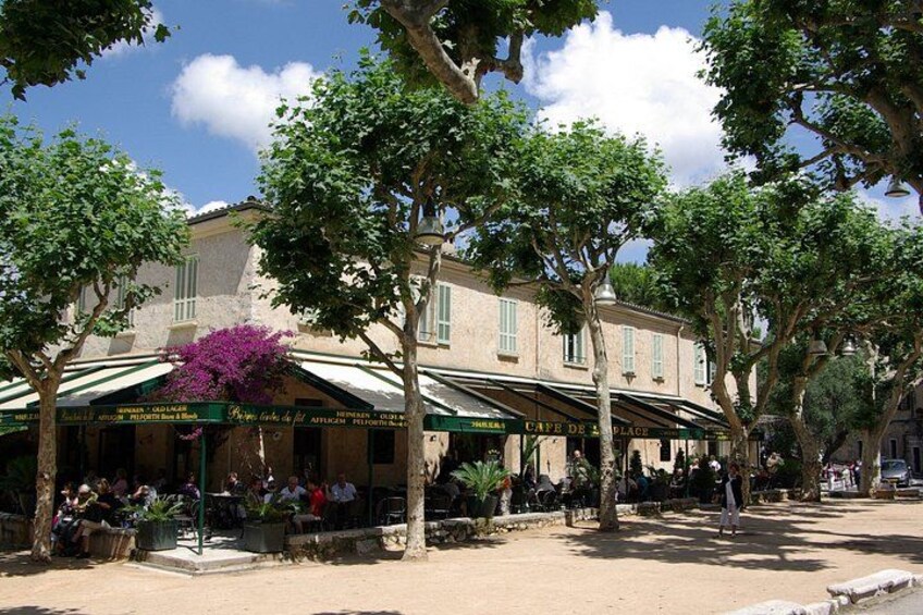 A café with outdoor seating, surrounded by trees and a clear sky. 2