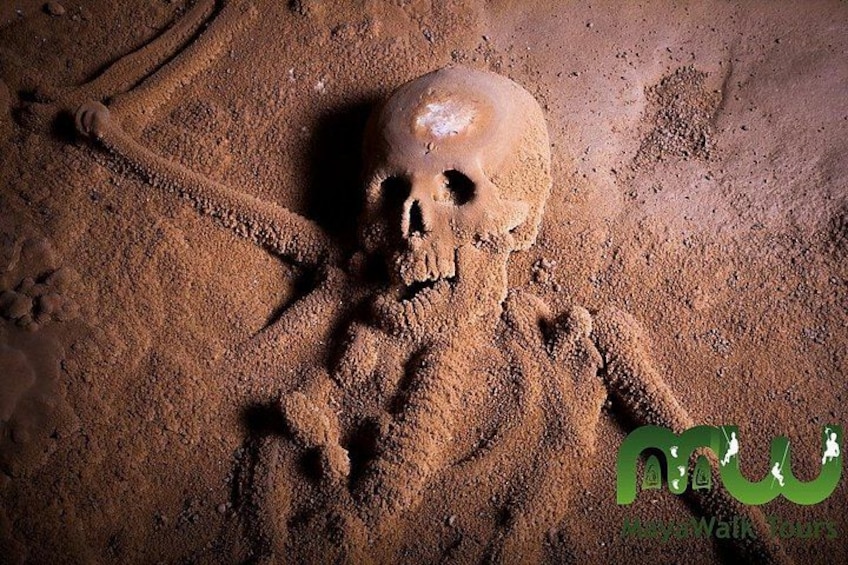 A sand sculpture of a human figure with a skull, surrounded by sand. 2