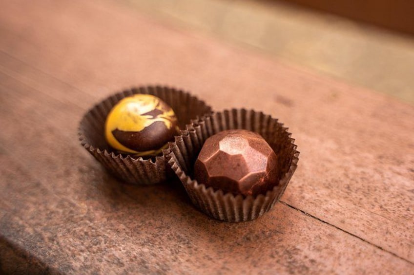 Deux chocolats dans des emballages en papier, posés sur une surface en bois. 3