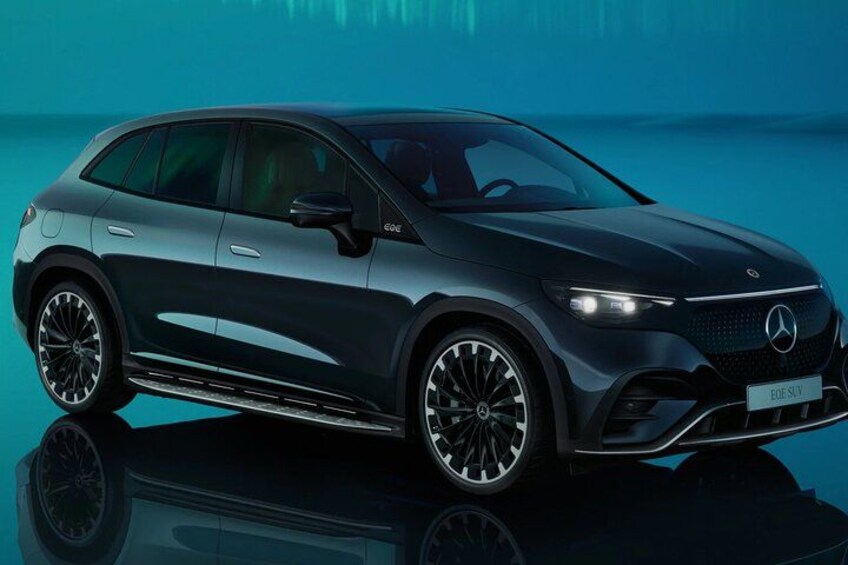 A dark-colored SUV with a sleek design, large wheels, and a visible license plate. 2