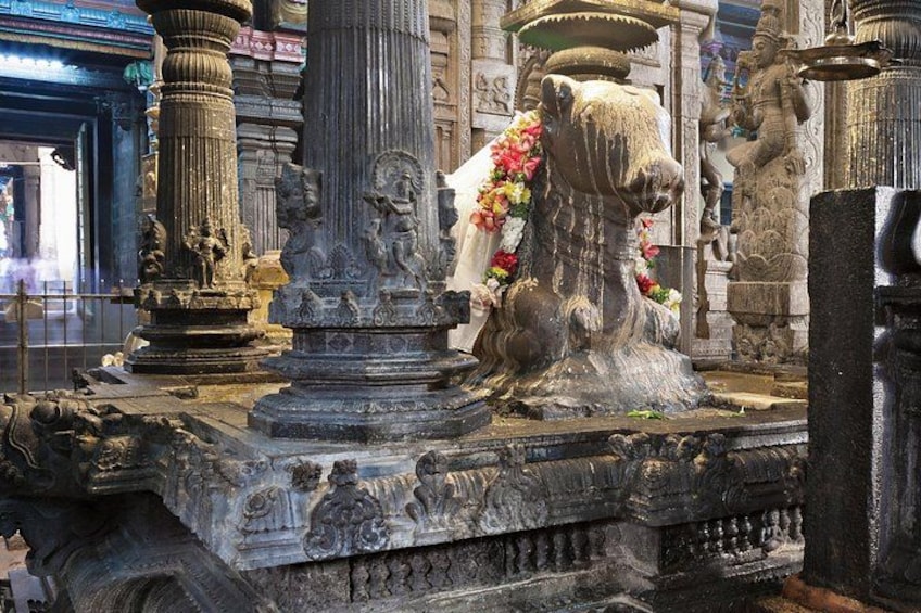A temple with intricate stone carvings, a large elephant statue, and a deity figure. 3