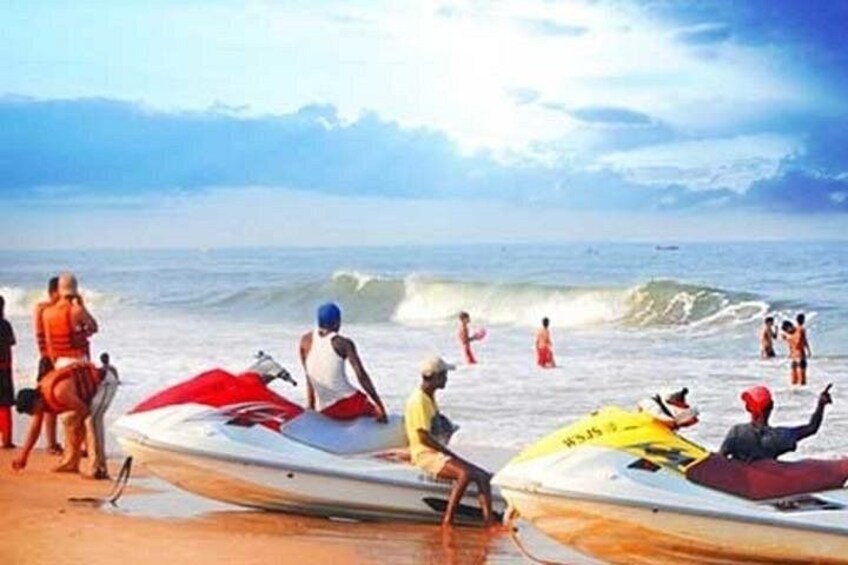 Una playa con gente en botes y en la orilla. 3