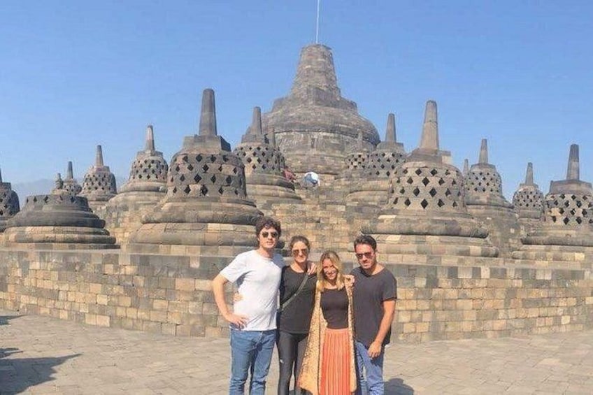 A group of people standing in front of a temple with multiple tiered roofs. 1